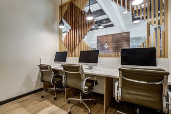 a conference room with computers and chairs and a staircase